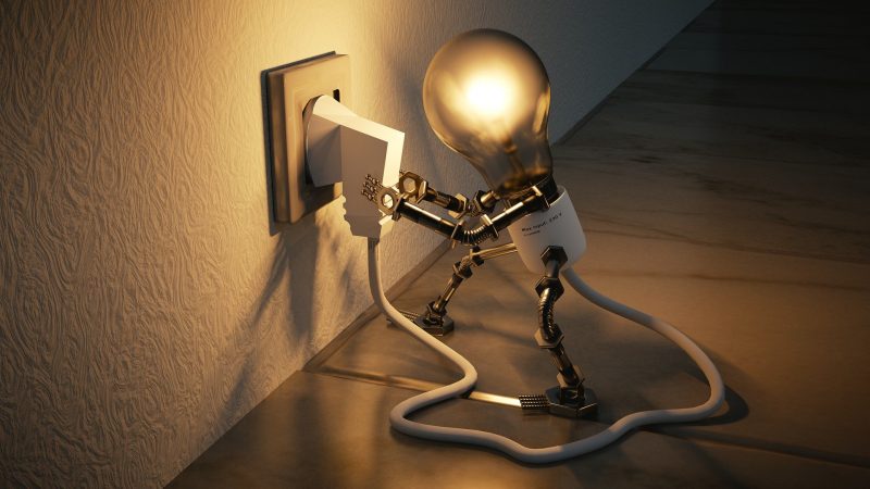 A lightbulb with arms and legs, plugging itself in